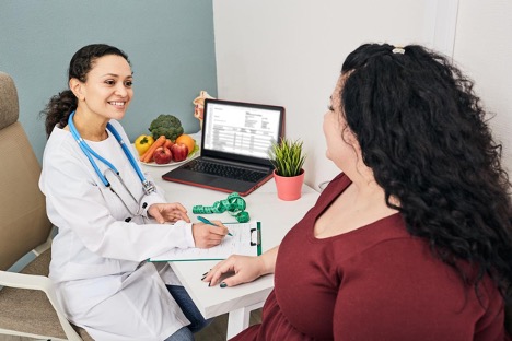 An obese female patient consults with her nutritionist for a diet plan meal